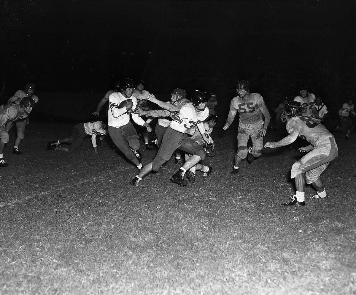 1950: Jimmy Blanton, Arlington Heights back, rambles for seven yards against Stephenville in the second period at Farrington Field. Reaching to make the tackle is Herman Kaughman (32) of Stephenville. Leading the play is Joe Keeton (35), while Kenneth Harlow (33) watches from the background.