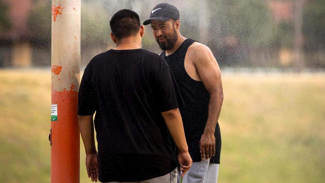 Eduardo Gomez Jr. and Eduardo Gomez cool off at a mister along the Trinity Trail in July. Extreme heat places a strain on the body’s cardiovascular system, because it requires the heart to pump blood more rapidly to keep the body’s core temperature stable.