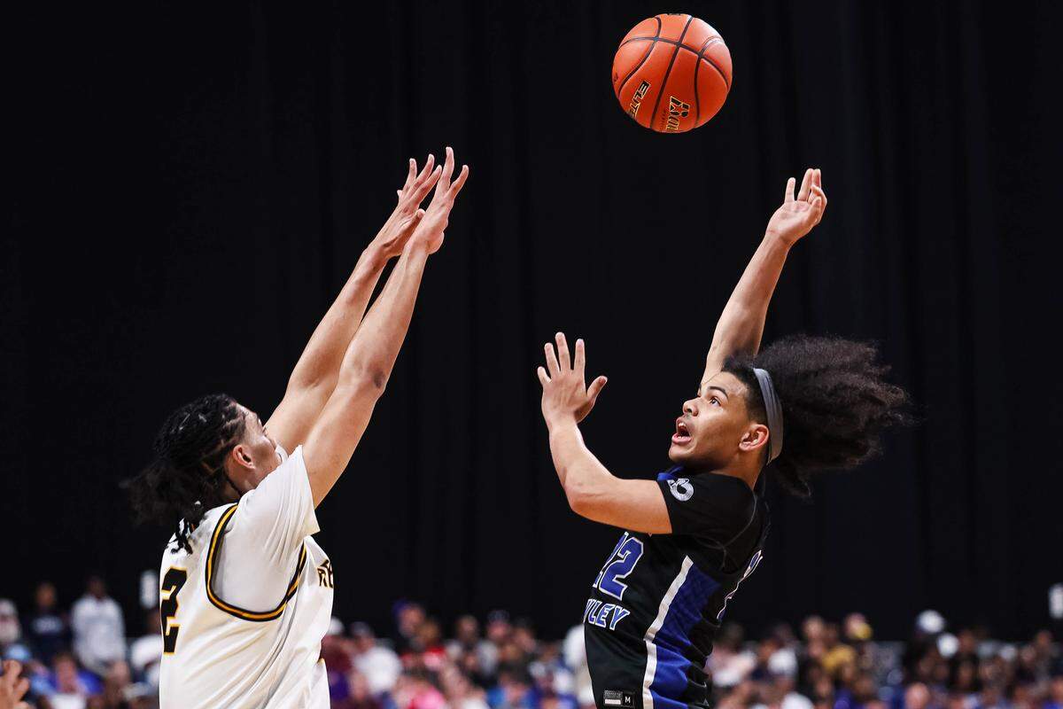North Crowley guard Isaak Hayes (right) puts up a shot over a San Antonio Brennan defender in the Class 6A Division I state championship game Saturday at the Alamodome in San Antonio.