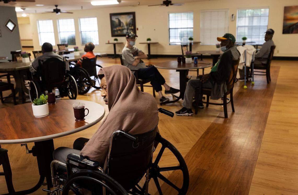 Residents at Heritage at Turner Park wait to be served their lunch by staff members. 