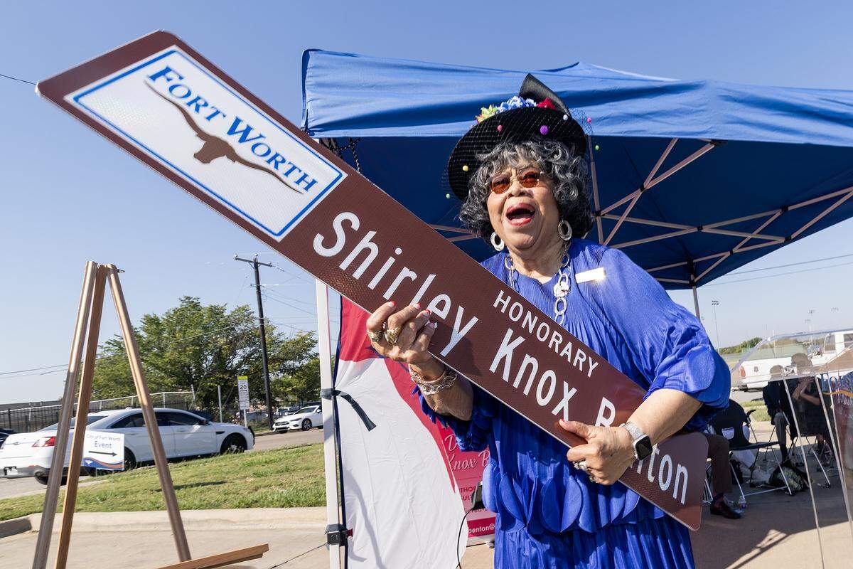 Former Dunbar principal Shirley Knox Benton reacts to seeing her street topper during a dedication ceremony in her honor outside Dunbar High School in Fort Worth on Thursday, Oct. 2, 2025. The tribute highlights Benton's lasting impact on Dunbar and its role in the broader Fort Worth community.