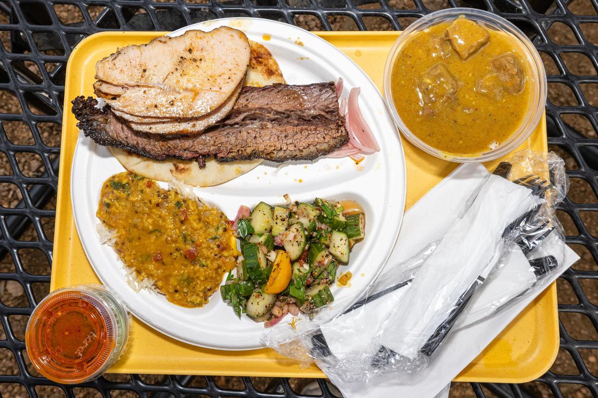 A three-meat plate with tandoori turkey, brisket and burnt ends nihari with a side of daal chawal (lentils over rice) and kachumber salad from Sabar BBQ in Fort Worth.