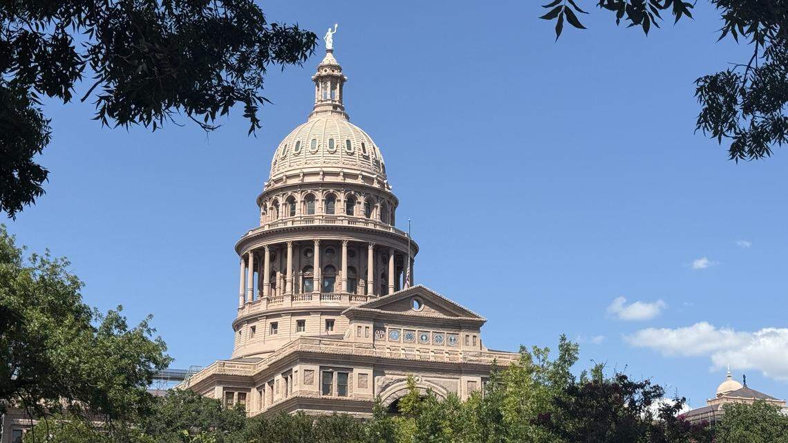 The dome of the Texas Capitol in Austin peaks over tree tops on Aug. 28, 2025.