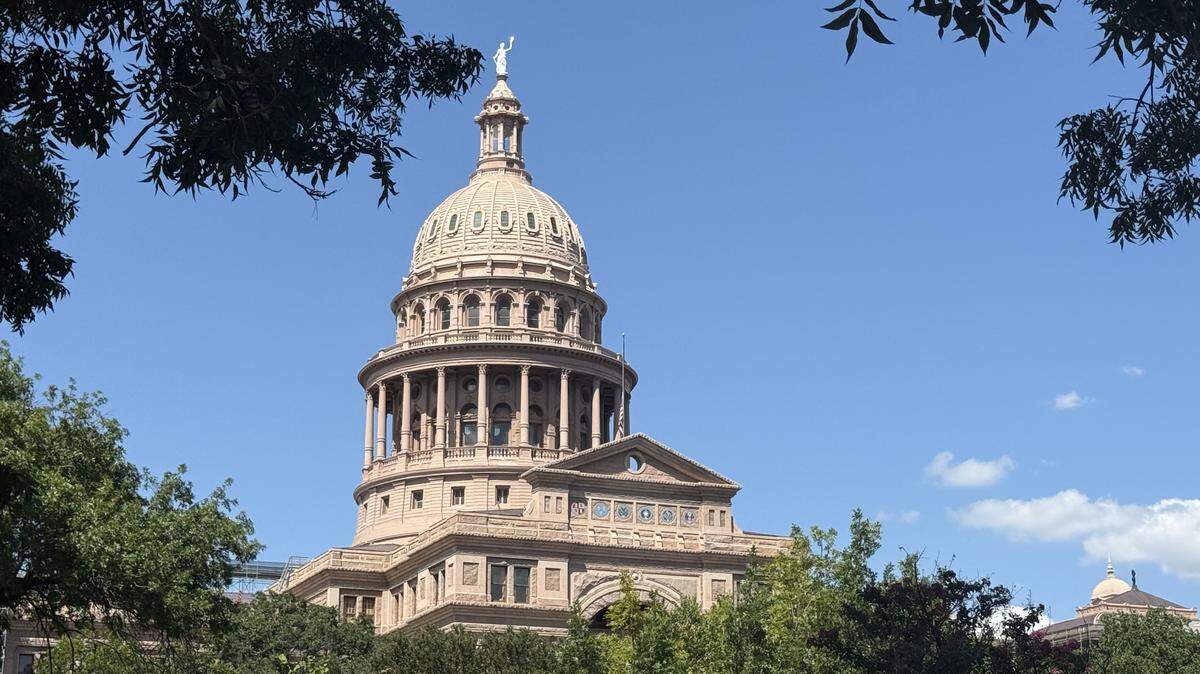 The dome of the Texas Capitol in Austin peaks over tree tops on Aug. 28, 2025.