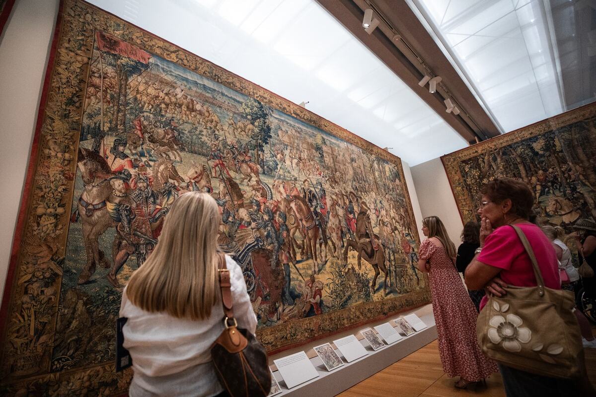 Guests look up at a tapestry on display during ‘Art and War in the Renaissance: The Battle of Pavia Tapestries’ exhibit on Friday at the Kimbell Art Museum. The tapestry depicts the capture of the King of France by imperial soldiers.