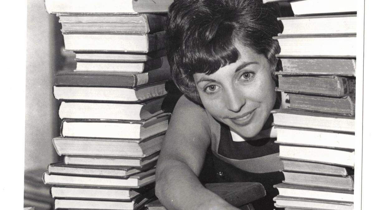 Marcia Kornbleet Kurtz peers through a veritable tunnel of used books in 1968 during the National Council of Jewish Women’s annual book fair, then held at Seminary South when it was the city’s only shopping mall.