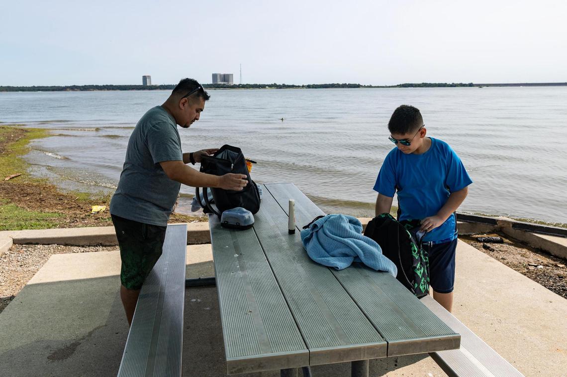 Dallas resident Juan Garcia, left, and his son Aaron, 11, unpack their things to prepare for their day at Grapevine Lake on May 31. Garcia believes a combination of the high lake water levels and lack of signage and safety precautions on the water have resulted in some recent accidents on the lake.