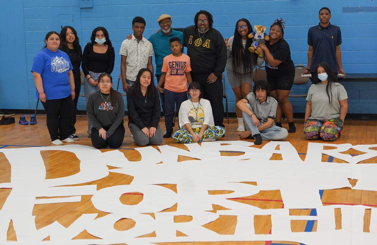 Dunbar High School students pose in front of their attempt to break the Guinness World Record for the world’s largest paper snowflake.