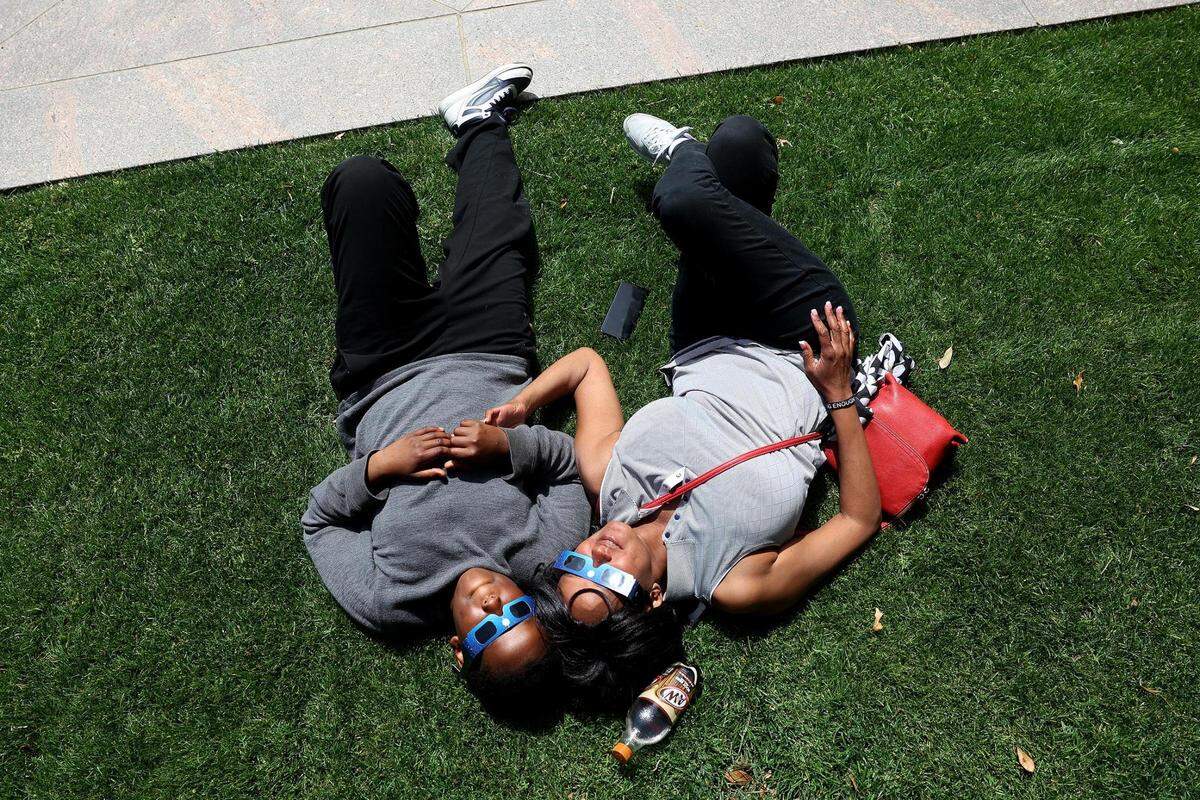 Patricia Wam and her son, Christian, 10, look into the sky during the total solar eclipse in at Burnett Park in Fort Worth on Monday, April 8, 2024.