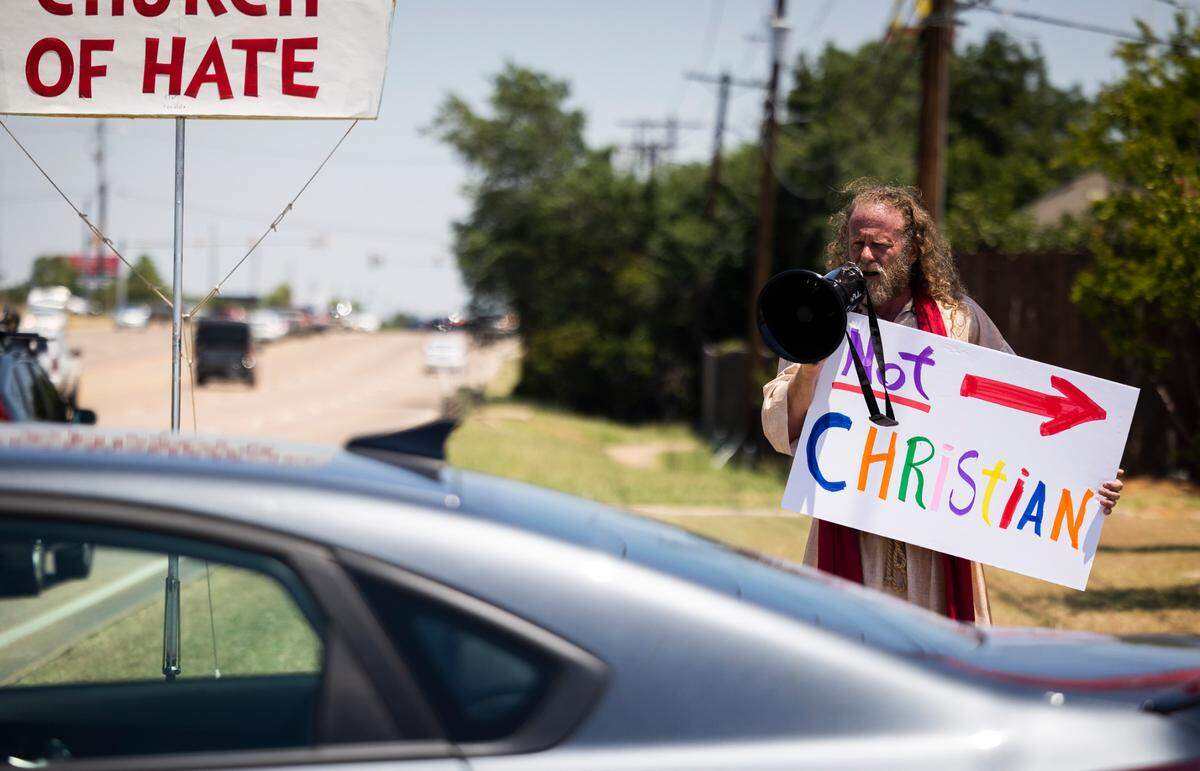No Hate in Texas protesters shout as churchgoers leave after service at Stedfast Baptist Church on June 26, 2022, in Watauga.