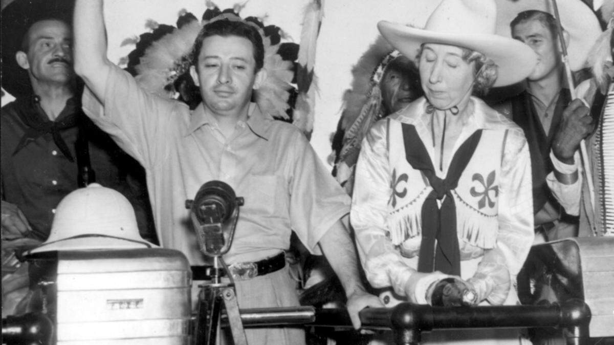 Billy Rose and Mrs. Verne Elliott extend welcome to visitors on opening day of the Fort Worth Frontier Centennial, July 18, 1936.