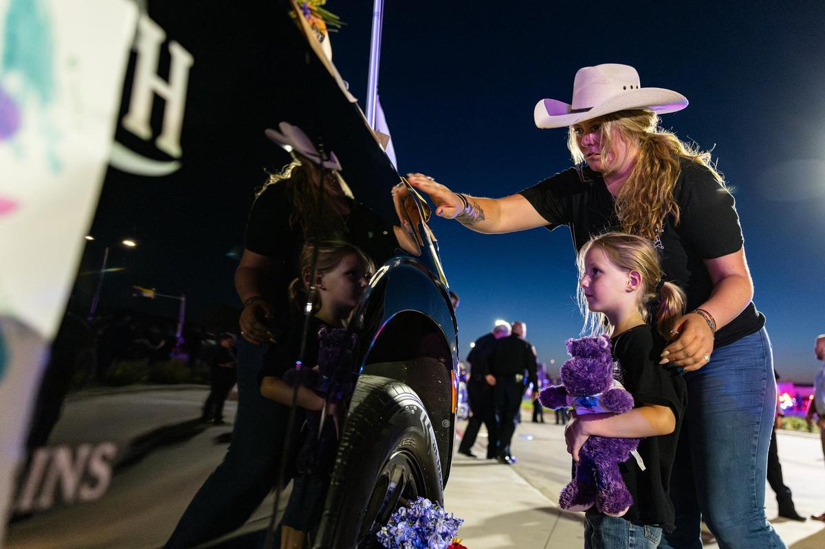 Tejal Gibson and her niece Nyla, 6, put a sticky note on the patrol car of Fort Worth Police Department Sgt. Billy Randolph in his memory during his honorary vigil at the Fort Worth PD South Division headquarters in Fort Worth on Wednesday, Aug. 14, 2024. Sgt. Randolph was struck by a vehicle while working a crash scene on the exit ramp of IH-35W near Sycamore School Road Monday morning.