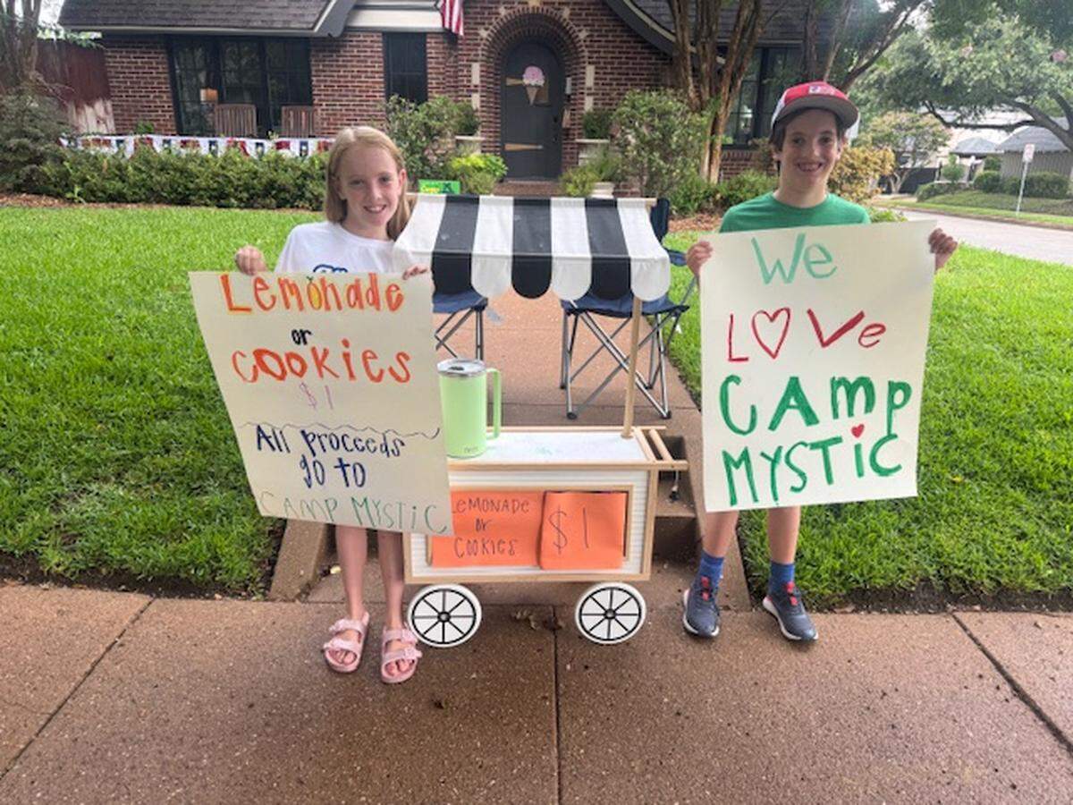 Siblings Corrigan and Cannon Camp, 9-year-old twins, pose in front of their lemonade stand in Fort Worth on Sunday, July 6, 2025, which raised more than $5,000 for Camp Mystic, an all-girls Christian camp that was devastated by flooding in Central Texas during the Fourth of July weekend. Corrigan attended Camp Mystic for two weeks in June.