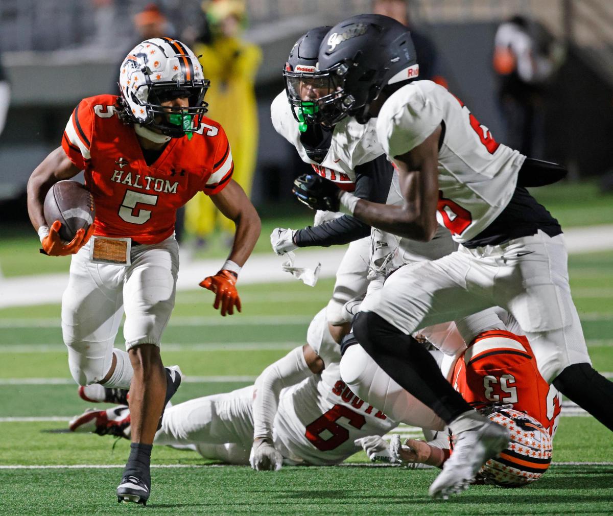 Haltom running back Vudrico Roberson (5) looks off two South Grand Prairie defenders during a UIL District 8-6A football game at Birdville Fine Arts/Activity Complex in North Richland Hills, Texas, Thursday, Oct. 31, 2024.