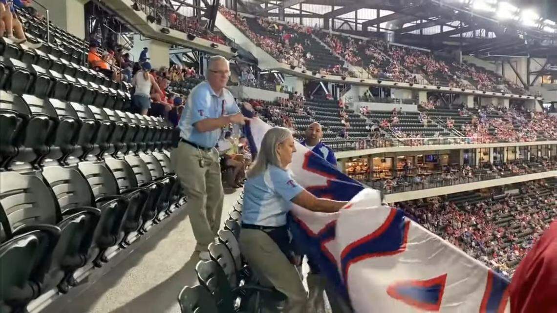 Texas Rangers security personnel remove a “Trump Won” flag that was briefly hung from the top level at Globe Life Field during Sunday’s game.