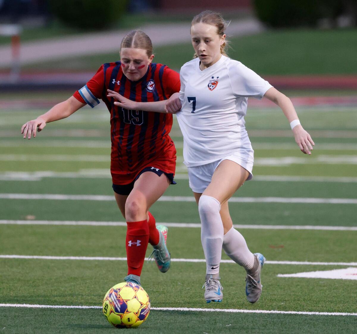 Grapevine forward Makena Kerr (19) defends against Frisco Wakeland midfielder Emma Sapp (7) during the Class 5A D2 UIL state semifinal girls soccer playoff game at Buddy Echols Field in Coppell, Texas, Friday, Apr. 05, 2025.
