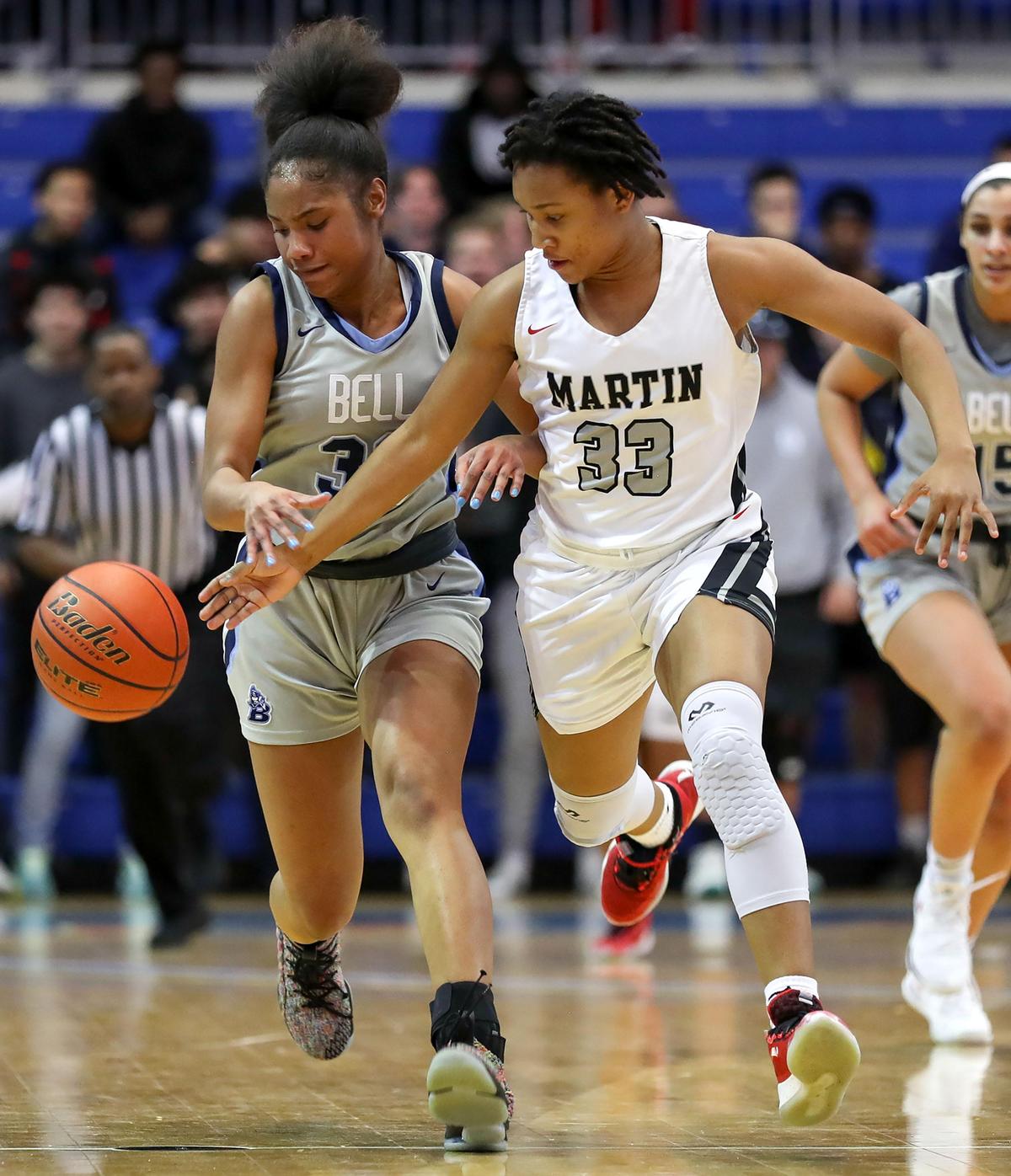 Arlington Martin guard Ariana Bracey (33) tries for a steal against L.D. Bell guard Hallie Rhodes (L) during the second half of the Girls Regional Quarterfinal Playoff basketball game, Tuesday, February 25, 2020 at the College Park Center on the UTA campus in Arlington, Texas.