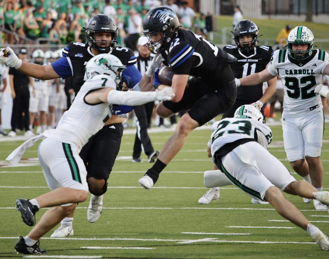 Byron Nelson running back Cooper Kenner (22) leaps over Southlake defensive back Austin Bussmann (23) for yardage during the first half of a UIL football game between Southlake Carroll and Byron Nelson at Northwest ISD Stadium in Justin, Texas, Friday, Sept. 12, 2025.