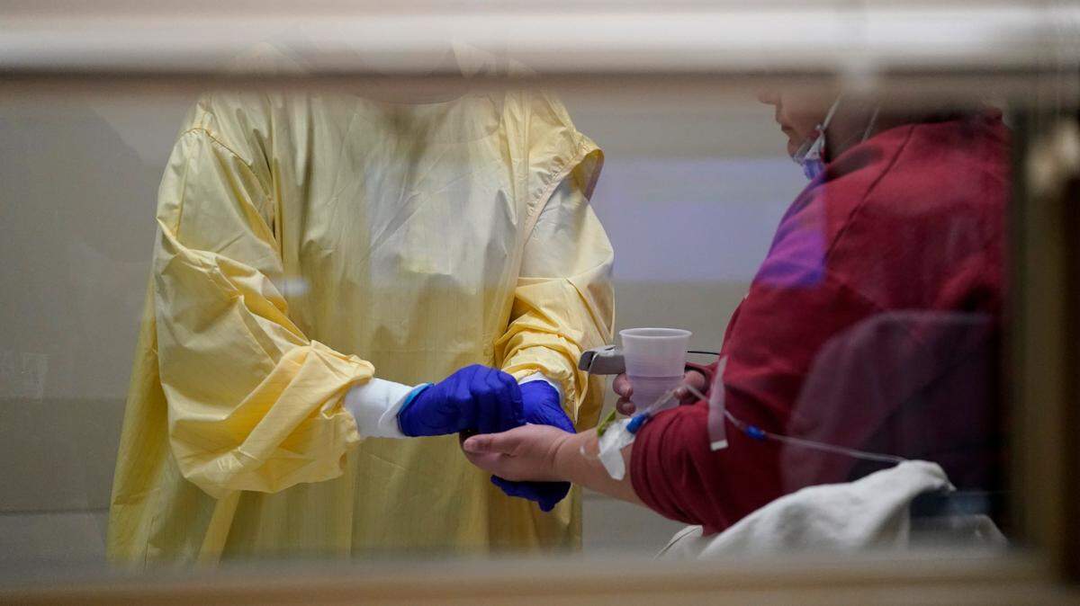 In this Nov. 24, 2020, file photo, registered nurse Chrissie Burkhiser, left, hands medication to a COVID-19 patient inside the emergency room at Scotland County Hospital in Memphis, Mo. States faced a deadline on Friday, Dec. 4, 2020, to place orders for the coronavirus vaccine as many reported record infections, hospitalizations and deaths, while hospitals were pushed to the breaking point — with the worst feared yet to come.