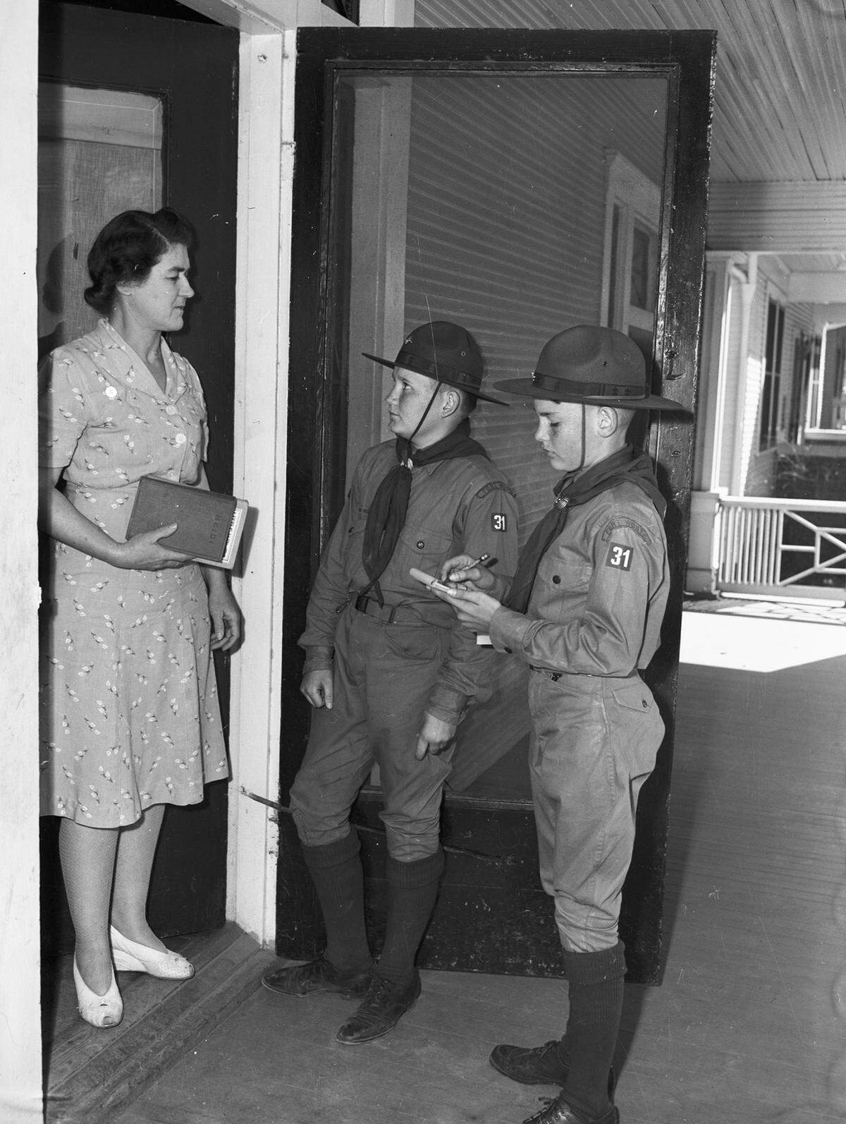 Feb. 11, 1943: As a part of National Boy Scout Week, scouts will go door-to-door asking residents to bring books for the Victory Book Campaign to schools when they register for Ration Book 2, Feb. 24-27. Standing at the door is Mrs. R.C. Reynolds. The scouts collecting books are Patrick Finn and Billy Singleton, of Troop 31 at Saint Mary’s Catholic Church.