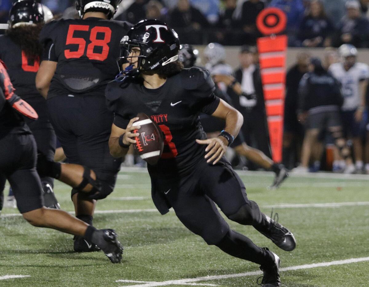 Trinity’s TJ Tupou rolls out looking for a reciever during a UIL football game at Pennington Field on Thursday, November 7, 2024.