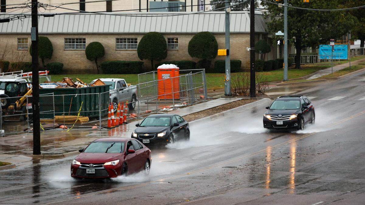 Cars drive through pooled water on Hulen Street as rains continues into Wednesday, Feb. 8, 2023, in Fort Worth.