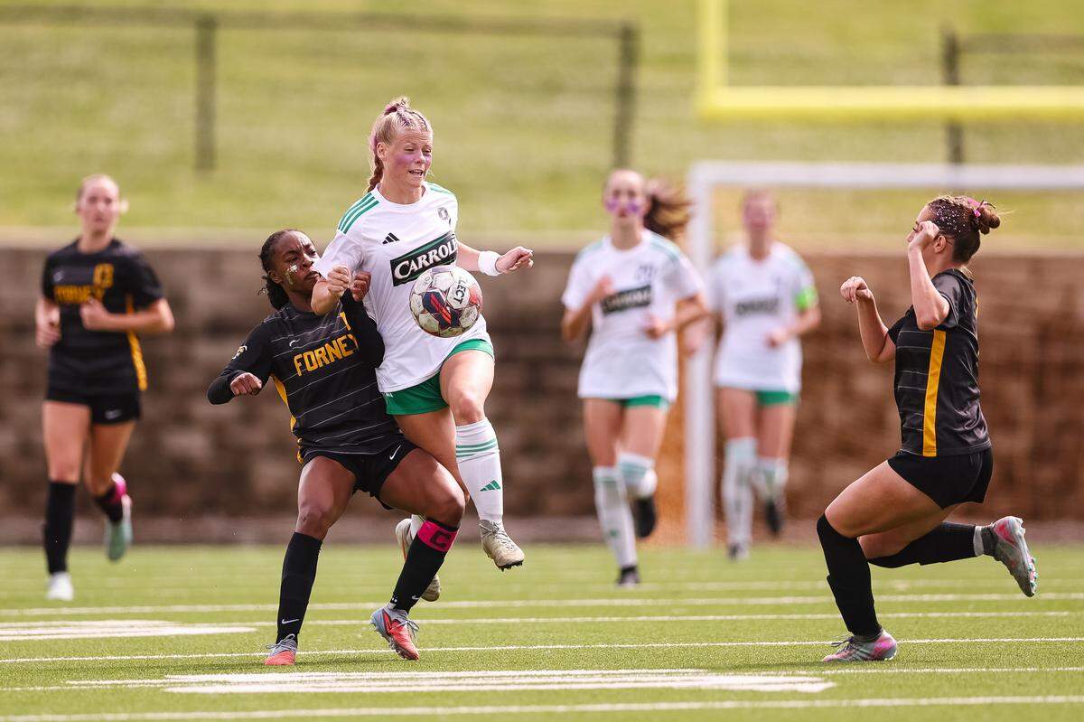 Southlake Carroll striker Caroline Holcombe (9) goes up with a Forney defender for the ball in a UIL Class 6A Division 2 girls soccer state semifinal on Saturday, April 4, 2026, at Memorial Stadium in Mesquite, Texas.