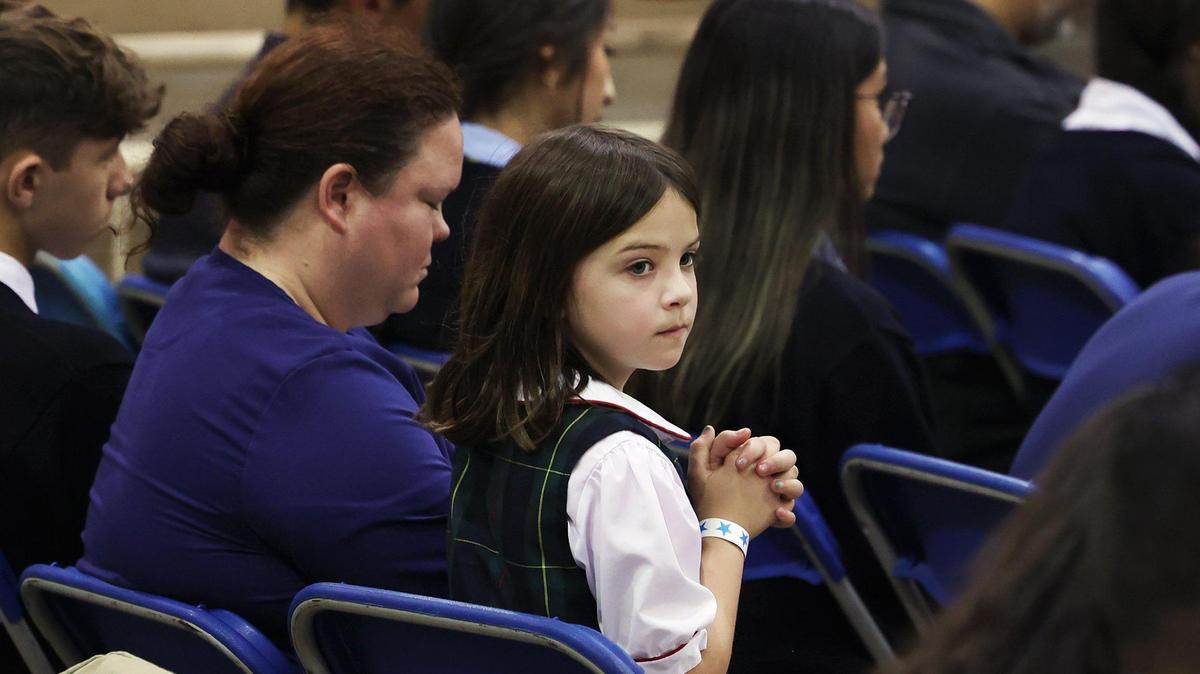 Members of the audience pray before the start of a program featuring Gov. Greg Abbott at Nolan Catholic High School on Wednesday, April 19, 2023. Abbott was rallying support for Senate Bill 8, which would give families $8,000-per-student in taxpayer money to pay for private schooling through an educational savings account.