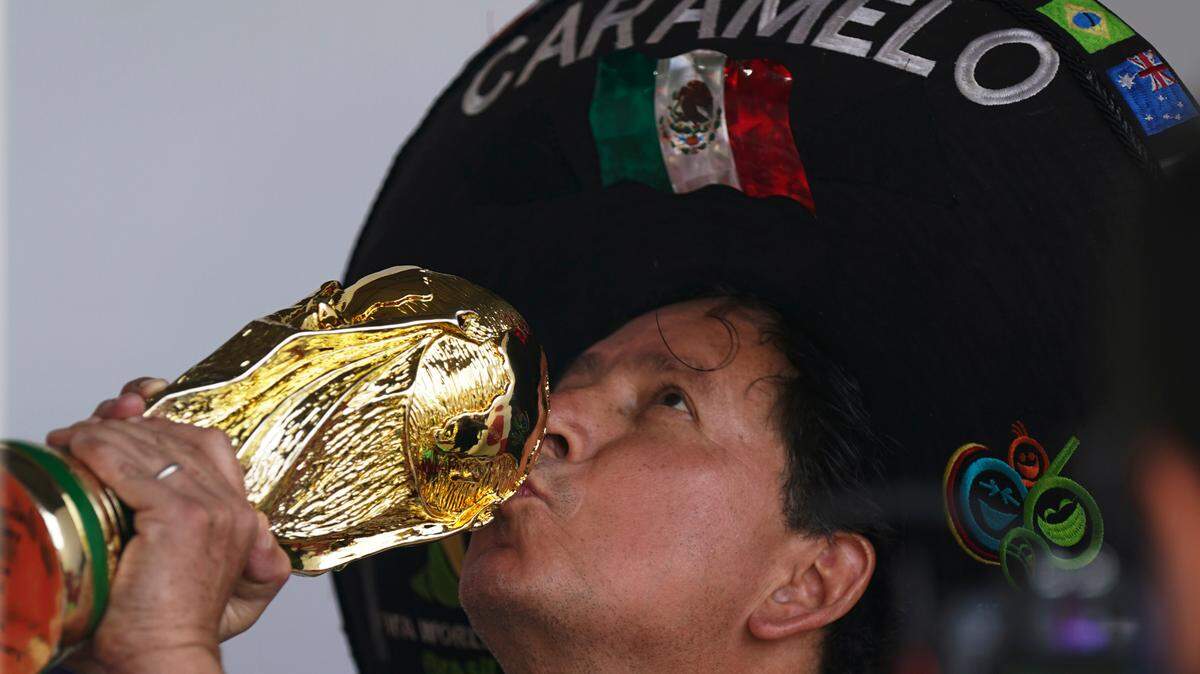 Mexico national soccer team fan Hector Chavez, also known as Caramelo, poses with a replica of the World Cup trophy in the Iztapalapa neighborhood of Mexico City, Sunday, Oct. 16, 2022. Super fan Caramelo claims Qatar will be the 10th World Cup he has attended.