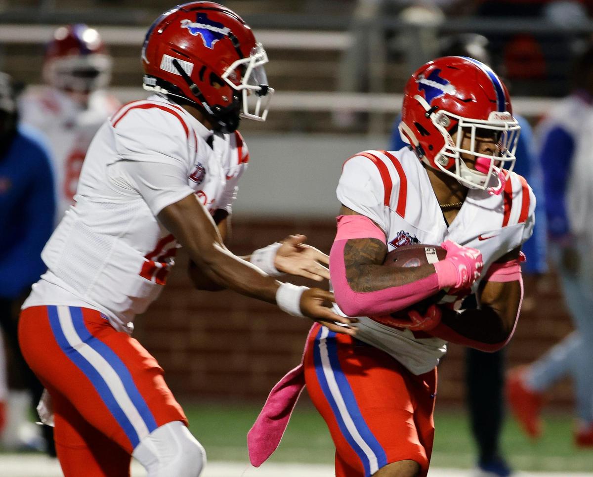 Duncanville quarterback Keelon Russell (12) hands the ball to running back Caden Durham (29) in the first half of a UIL high school football game at Vernon Newsom Stadium in Mansfield, Texas, Thursday, Oct. 12, 2023.