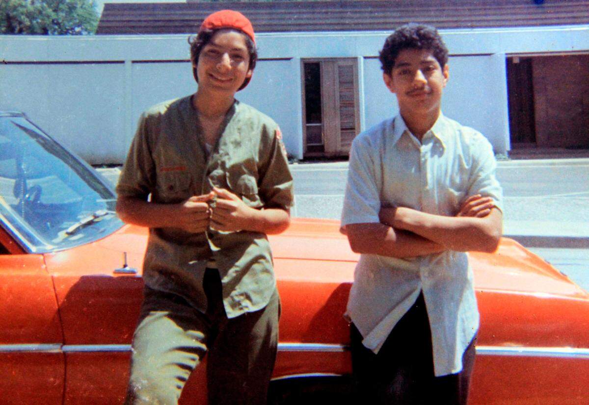 David Rodriguez, 13, left, and his brother Santos Rodriguez, 12, stand by a relative’s car in 1973 just one month before Santos was killed.