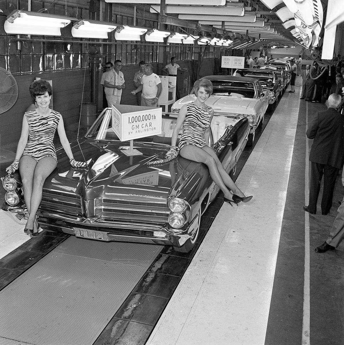 July 19, 1965: A shining 1965 Pontiac convertible moves down the General Motors assembly line to become the 1 millionth automobile produced at the Arlington plant, which opened in 1954. Two models, Betty Cremer and Shirley Deis, wearing tiger outfits sit on the hood.