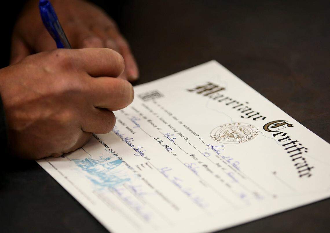 Manuel Medrano Santoyo and Maria Cortes Maciel sign their marriage certificate in 2023 at the Marion County Justice Court in Salem, Oregon.