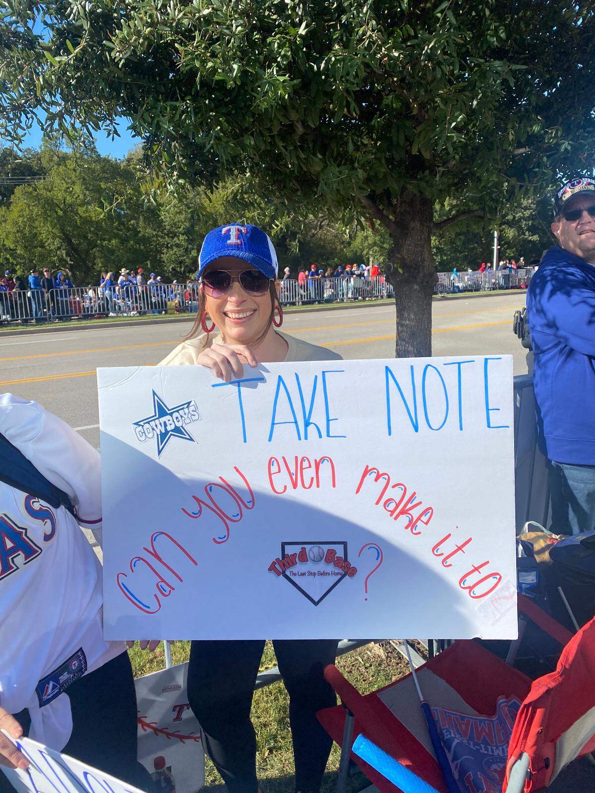 A Texas Rangers fan poses with a home-made sign before the World Series victory parade.