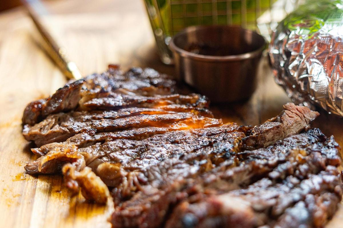 A blow torch is used to crust the edges of the Crying Tiger ribeye steak served with assorted vegetables and sticky rice at the new Ko Thai restaurant on Magnolia Avenue in Fort Worth on Tuesday, April 29, 2025.