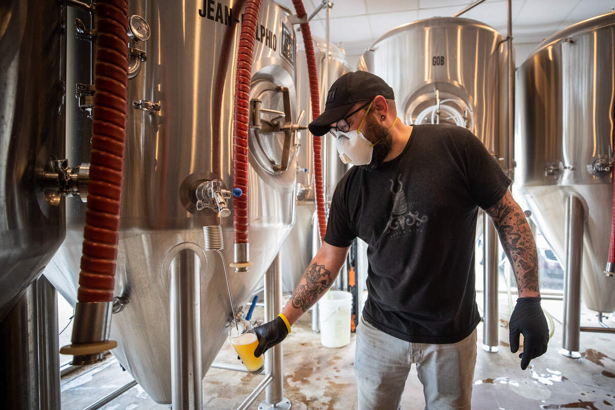 James Herrington pours beer from a tank for sampling at Turning Point Beer in April 2020.