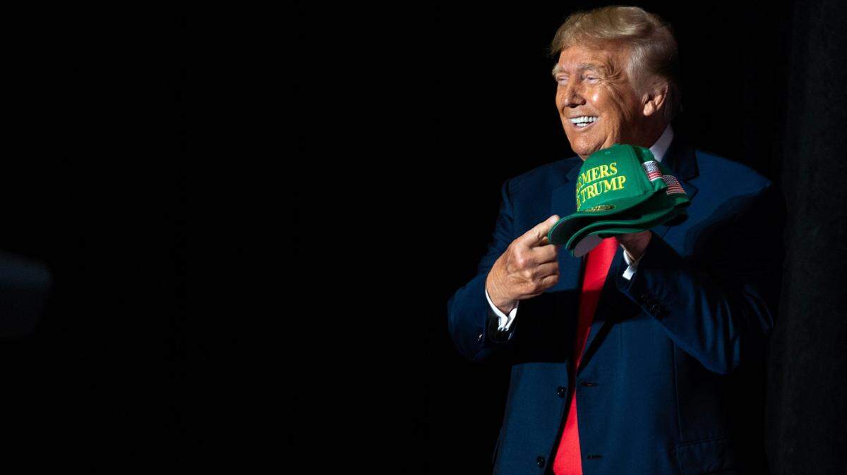 Former President Donald Trump holds up a Farmers for Trump hat during a campaign event, on Friday, July 7, 2023, at the Mid-America Center, in Council Bluffs.