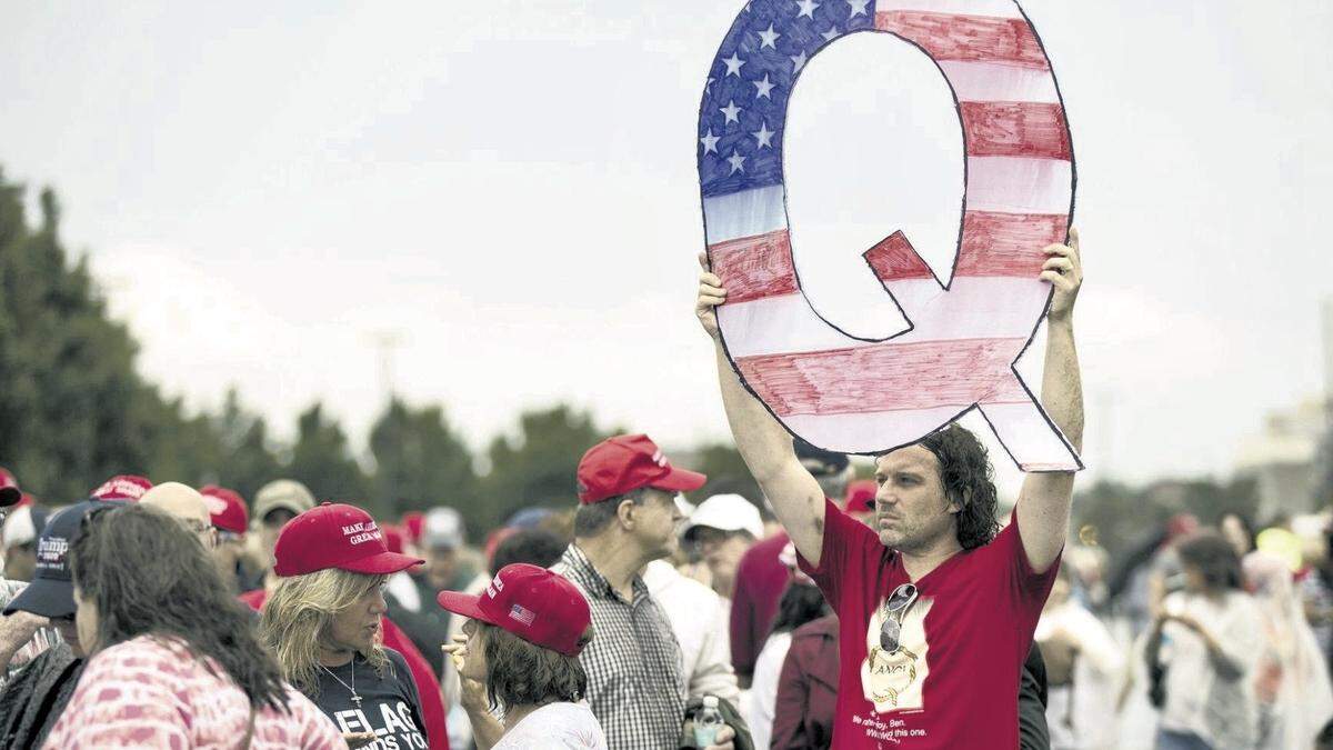 In this Aug. 2, 2018, file photo, David Reinert holding a Q sign waits in line with others to enter a campaign rally with President Donald Trump in Wilkes-Barre, Pa.