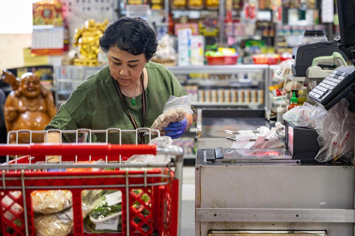 Dao Dang, one of the owners of Nguyen Loi Oriental Supermarket, works the cash register at her store in Haltom City on Sunday, May 11, 2025.