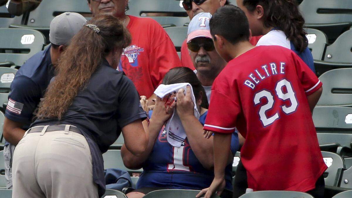A fan is bloodied after a foul ball hit her off the bat of Texas Rangers left fielder Willie Calhoun during the first inning of a baseball game against the Detroit Tigers Sunday, August 4, 2019, in Arlington, Texas. (AP Photo/Michael Ainsworth)