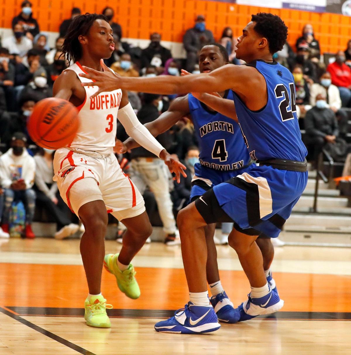 Haltom guard Quincy Haggerty (3) passes away from North Crowley guard Remon Tuck (4) and wing Trey Davis (24) during a District 3-6A Bi-district basketball game at Haltom High School in Haltom City, Texas, Friday, Feb. 12, 2021. North Crowley defeated Haltom 55-45. (Special to the Star-Telegram Bob Booth)