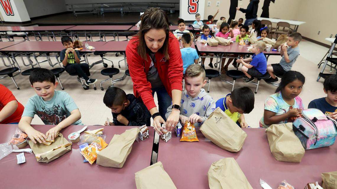 Sam Houston Elementary principal Jacy Roach, center, helps students with there lunch during a catch-up day on Friday, April 14, 2023. Mineral ISD shifted to a four-day school week that year but offered a catch-up day on Fridays for students who needed extra help, or for parents who needed a place to send their kids while they’re at work.