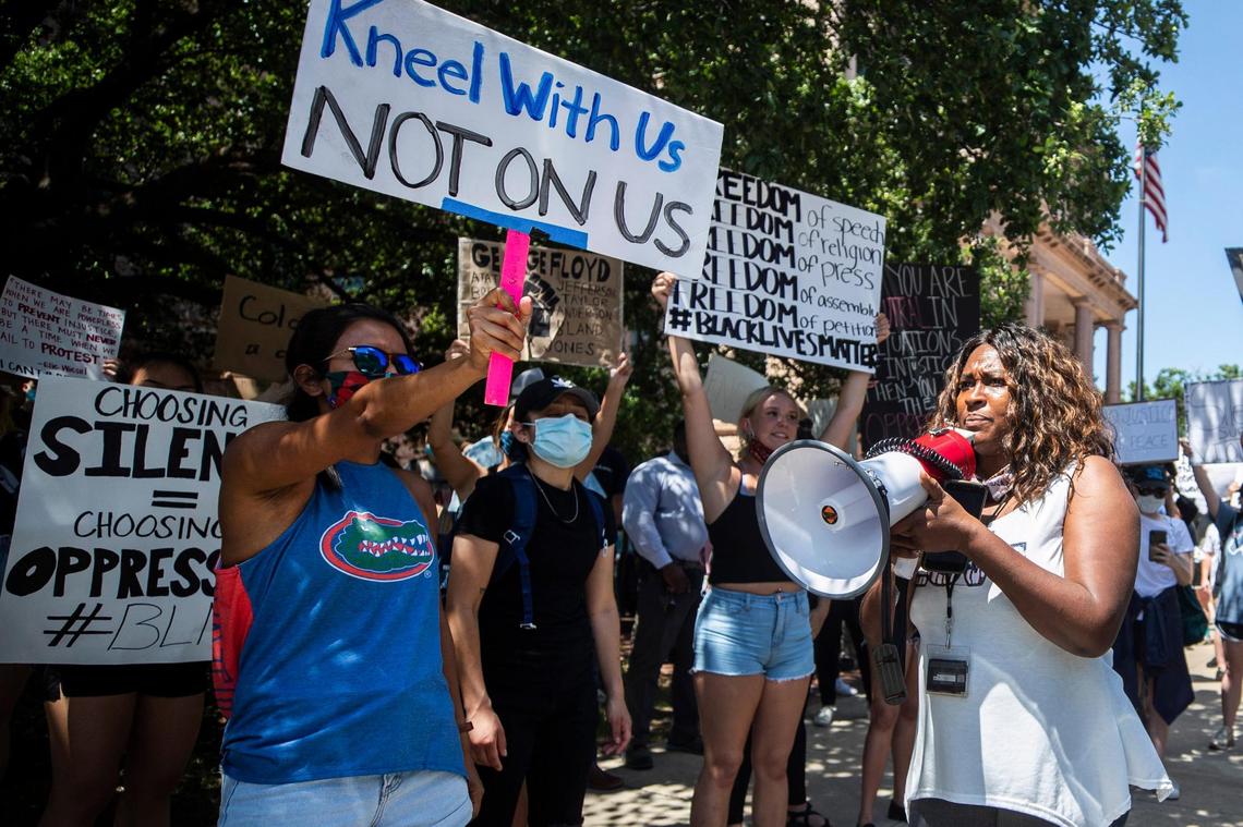 Carol Harrison-Lafayette (right) speaks to other protesters through a megaphone during a recent march in Fort Worth.