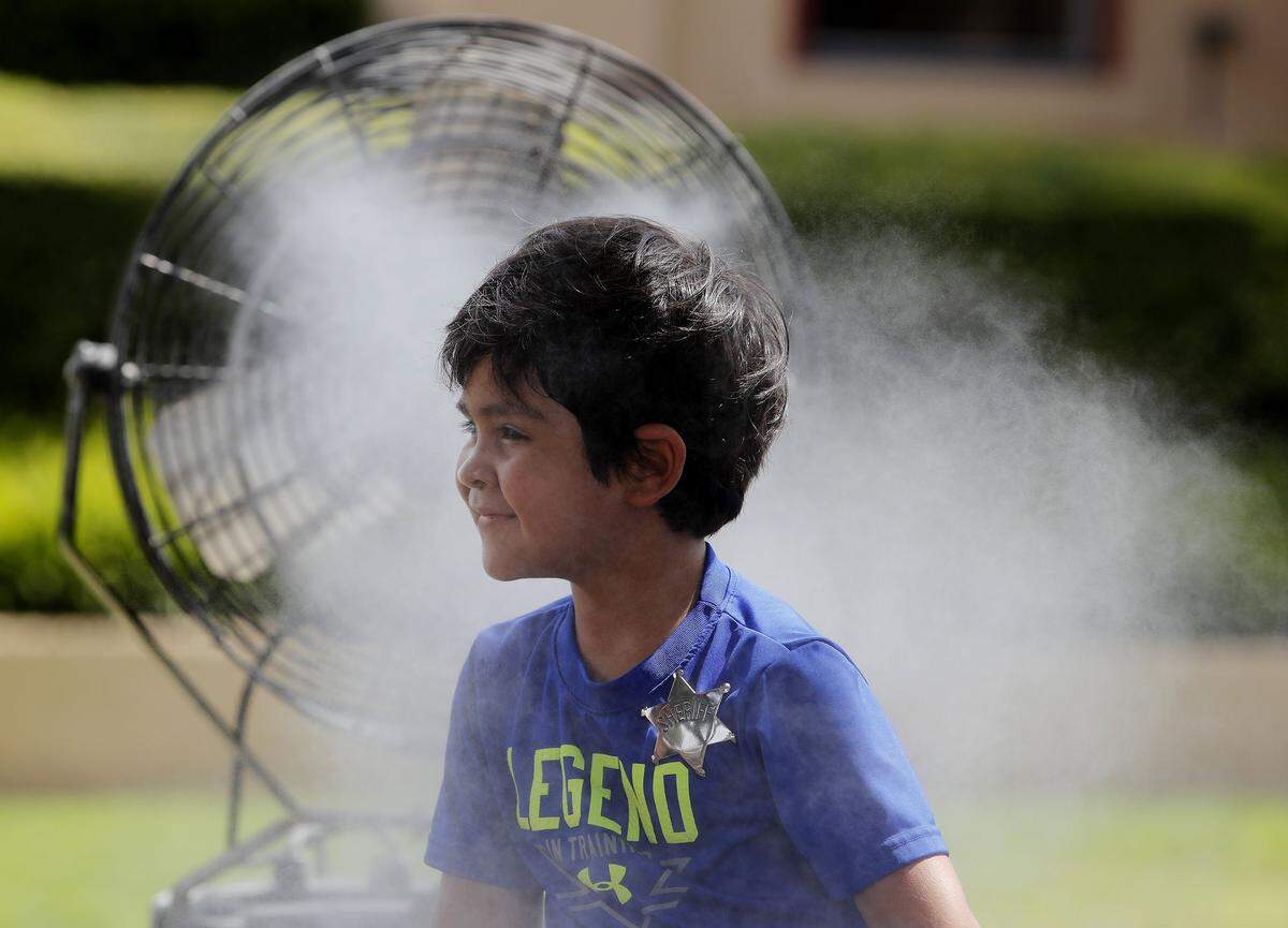 It’s been hot this summer as seen by Vincent Rodriguez (age 4, from Waco). He stayed close to a water-spray fan along East Exchange while visiting the Stockyards with his parents on July 20.