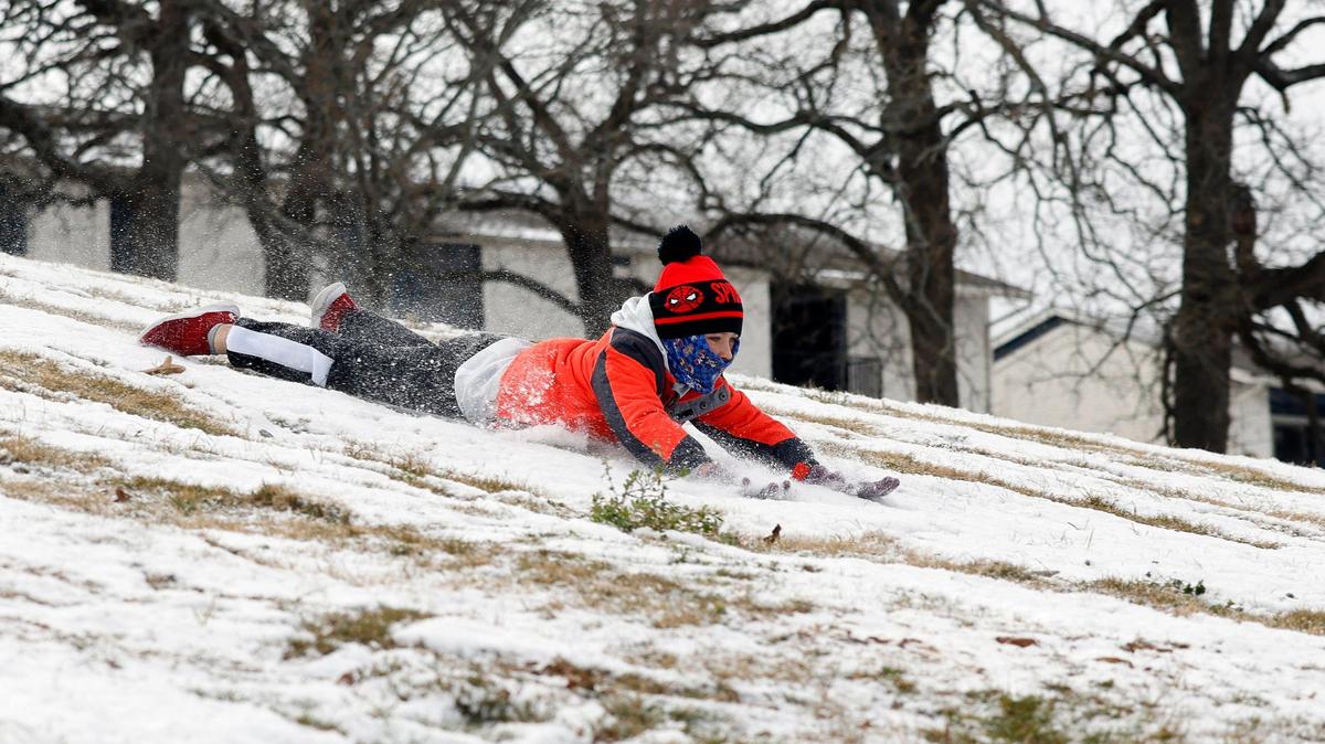 Bryson, 8 slides down a hill at Bedford Boys Ranch during the areas first freeze of the season in Bedford, Texas, Monday, Jan, 15, 2024. Temperature during the early morning was 9 with a wind chill of -7. (Special to the Star-Telegram Bob Booth)