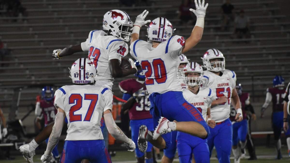 Grapevine players celebrate Meshack Ngoie’s (13) third-quarter interception in the Mustangs’ 51-0 victory over Southwest at Clark Stadium in Fort Worth Friday night.. (Michelle Escalante/special to the Star-Telegram)