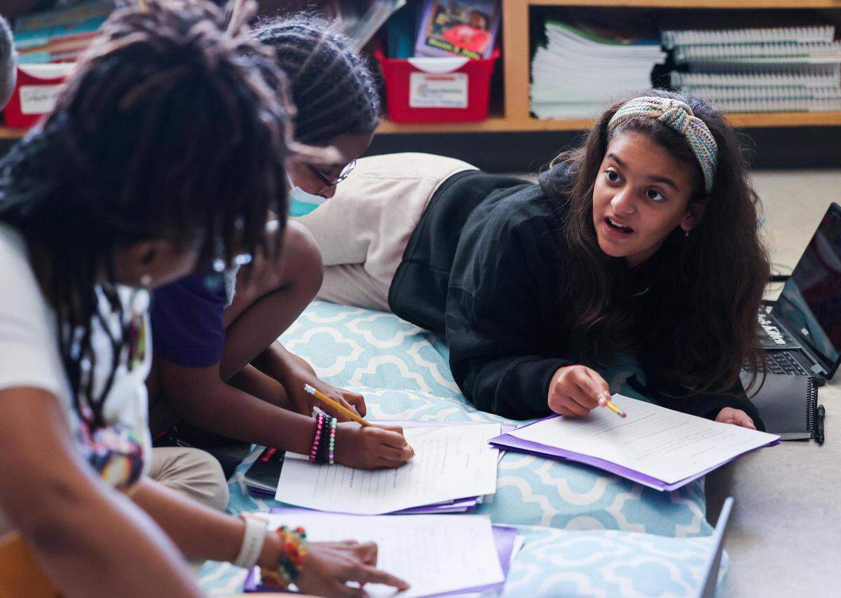 Jelianette Gonzalez looks over an assignment during a small-group discussion during Latressha Leonard’s fourth-grade class on Oct. 6, 2022, at the Leadership Academy at John T. White Elementary School.