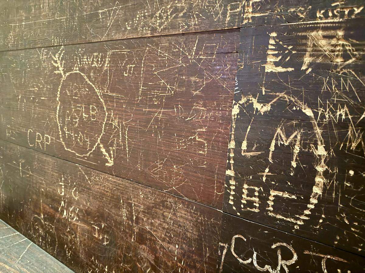 A wall in the entryway at the Candlelite Inn is covered with nearly 70 years of carved messages. Seen Dec, 8, 2025.