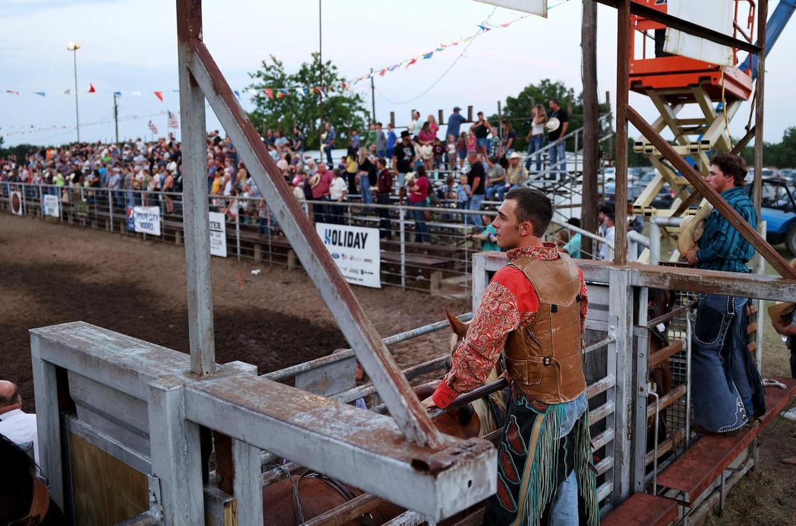 Cowboys wait their turn in the arena for the bronc riding competition at the Wolfe City Rodeo on Friday, Aug. 5, 2022. The small town rodeo attracts people from around the area to celebrate cowboy culture and horse riding for two nights.