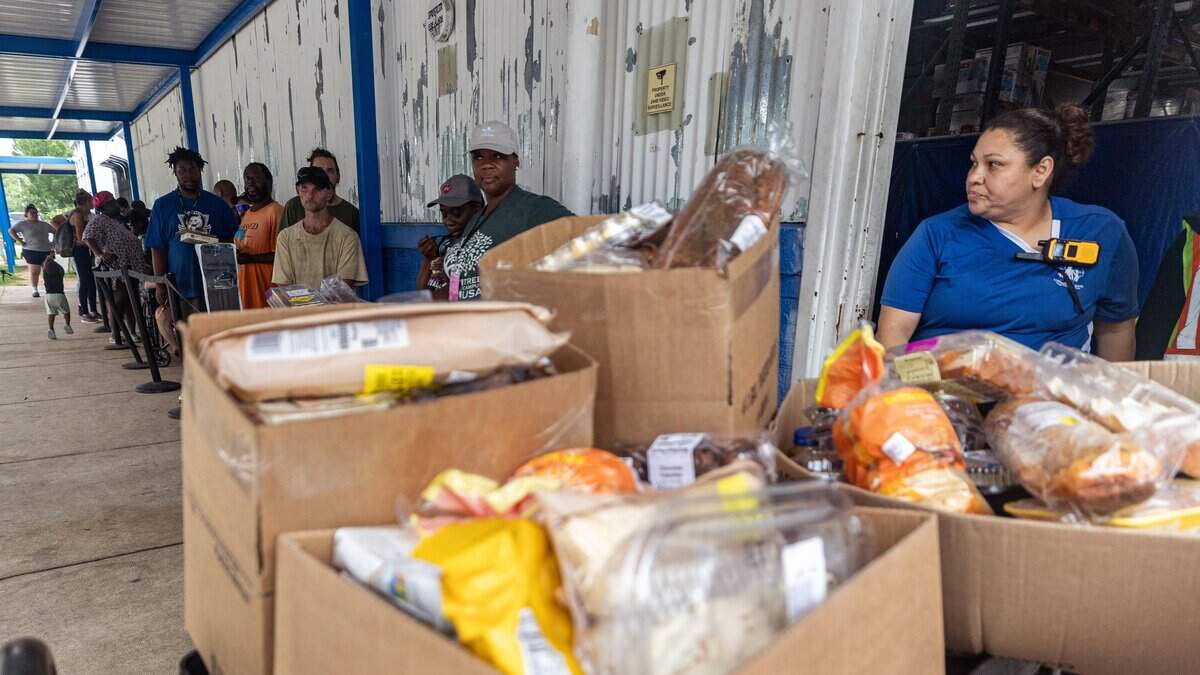 Staff member Judy Gutierrez checks on the line of people waiting for food outside the Community Food Bank of Fort Worth on June 15, 2026. The Community Food Bank serves an average of 500 families a day.
